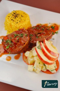 Beef Medallions wrapped in bacon with yellow rice and an apple salad 